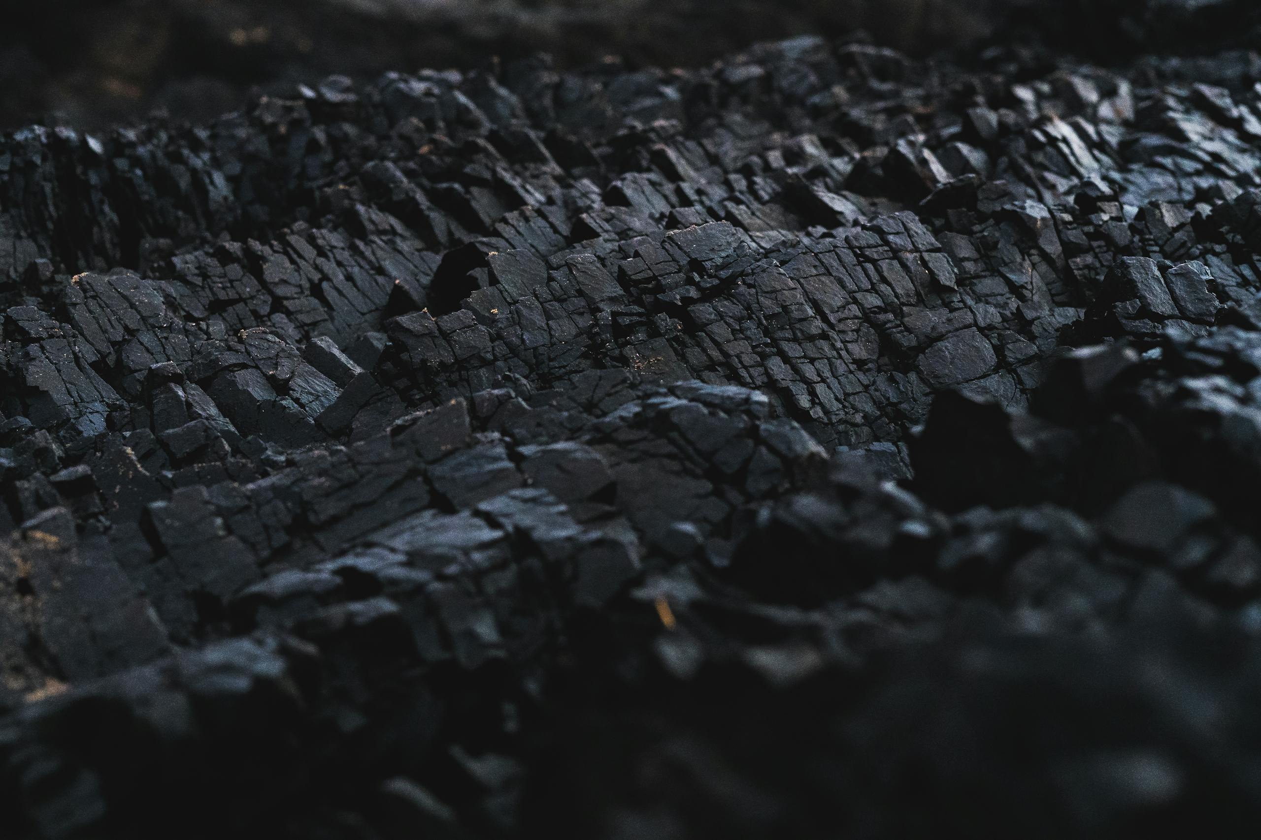 A detailed close-up of dark charcoal texture, showcasing its rough and jagged surface.